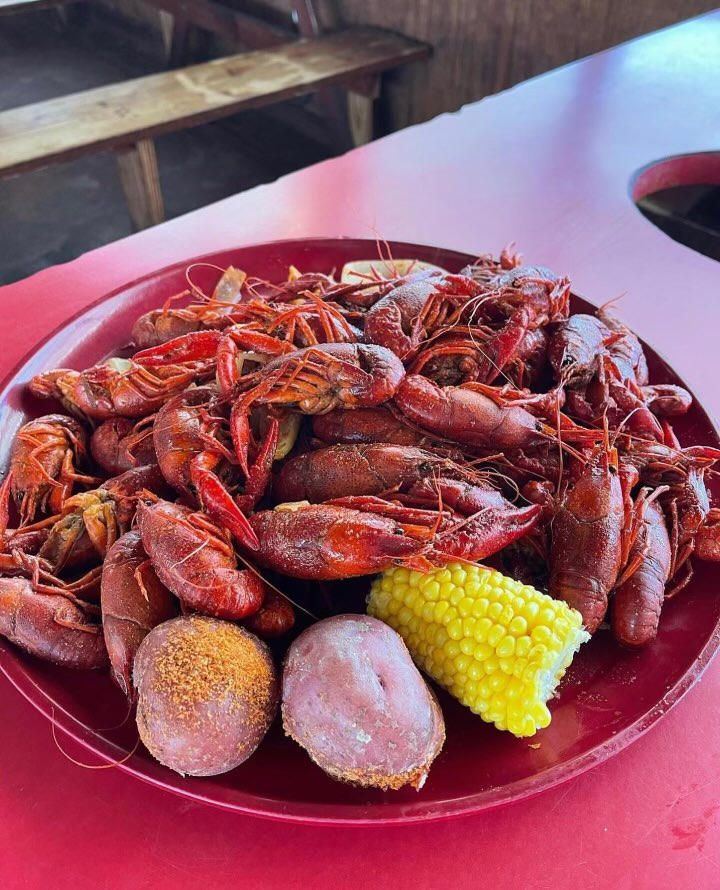 Boiled crawfish with corn and potatoes on a red tray